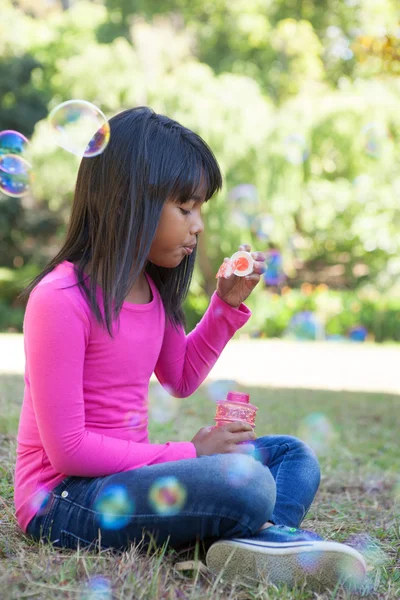 Roztomilá malá holka foukání bublin — Stock fotografie