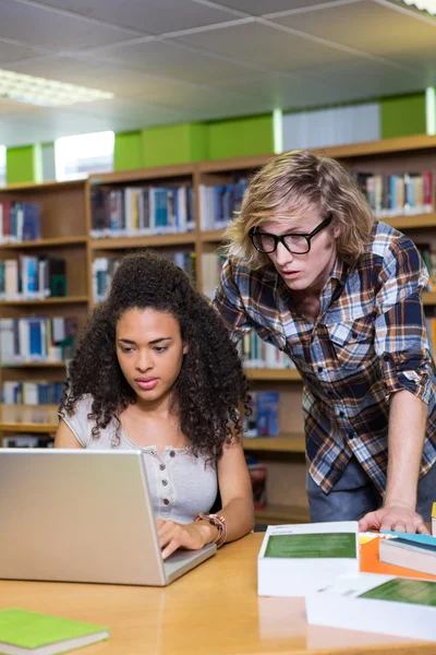 Student, uzyskanie pomocy od kolegę w bibliotece — Zdjęcie stockowe