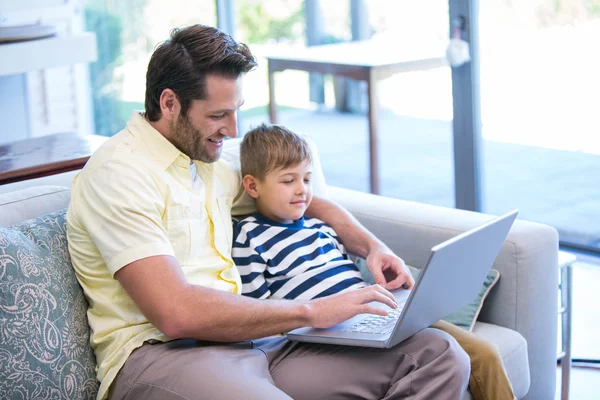 Ojciec i syn korzysta z laptopa na kanapie — Zdjęcie stockowe