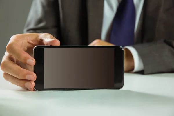 Empresario mostrando su teléfono inteligente — Foto de Stock