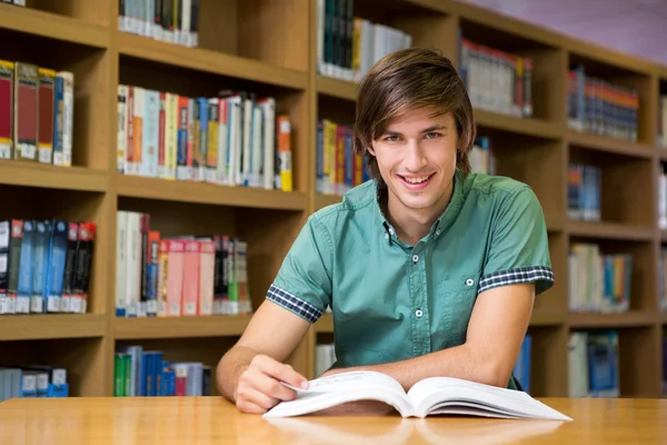 Student sedí v knihovně a čtení — Stock fotografie