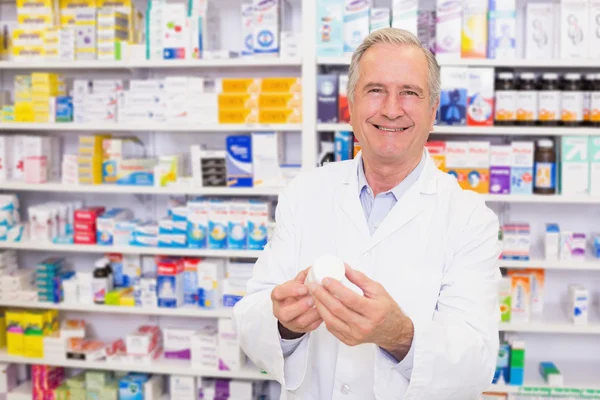 Farmacéutico sonriente sosteniendo una caja de pastillas — Foto de Stock