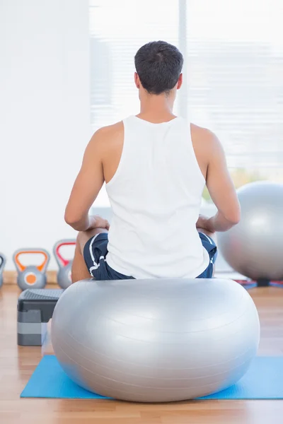 Homem sentado na bola de exercício — Fotografia de Stock