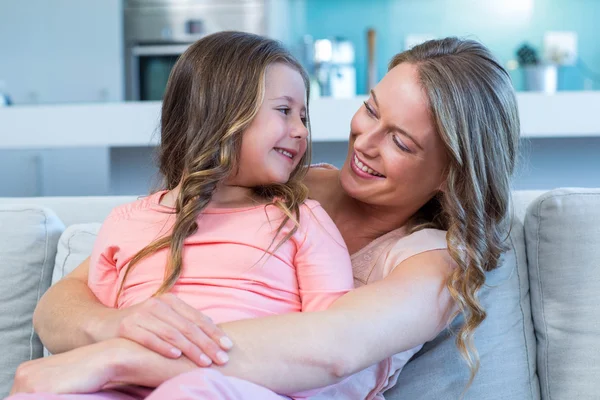 Mother and daughter hugging on couch — Stock Photo, Image