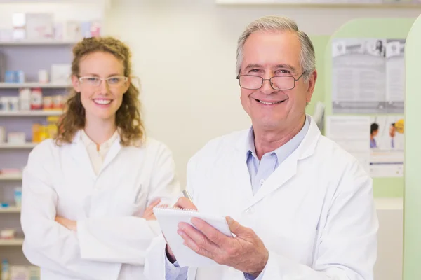 Pharmacist and his colleague at pharmacy — Stock Photo, Image
