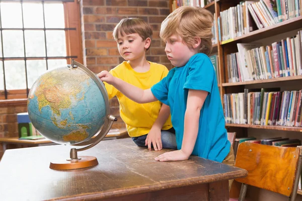 Niedliche Schüler schauen auf Globus — Stockfoto