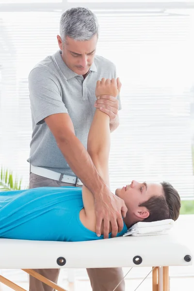 Doctor examinando su brazo paciente —  Fotos de Stock