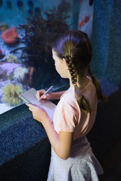 Cute girl looking at fish tank — Stock Photo, Image