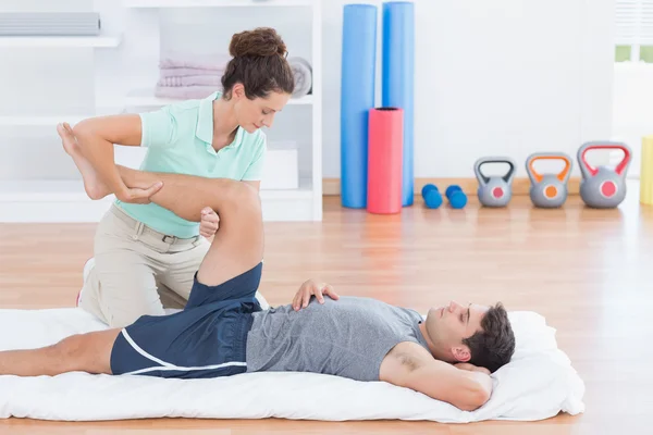 Man die met zijn trainer zich uitstrekt — Stockfoto