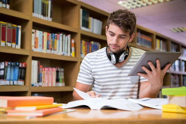 Estudiante estudiando en la biblioteca con tablet — Foto de Stock