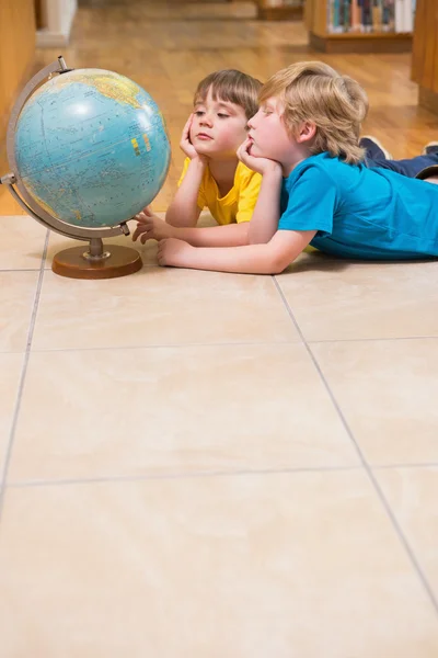 Carino alunni guardando globo — Foto Stock