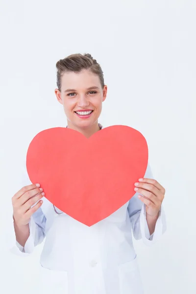 Smiling doctor holding heart card — Stock Photo, Image