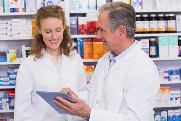 Equipe de farmacêutico olhando para tablet pc — Fotografia de Stock