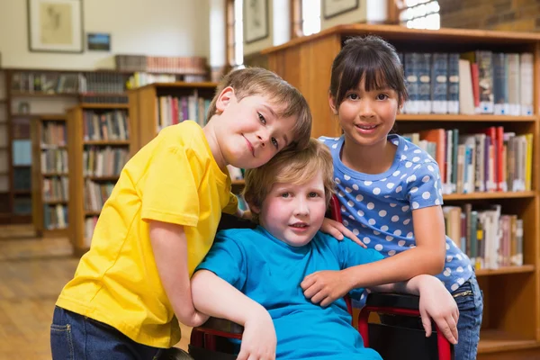 Şirin öğrencilerin kütüphanede sarılma — Stok fotoğraf