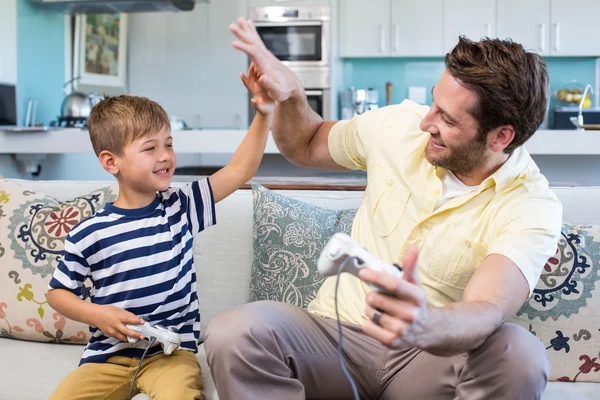 Pai e filho jogando videogames juntos — Fotografia de Stock