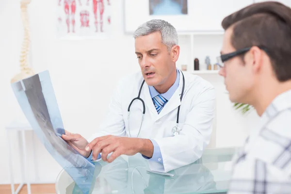 Doctor showing Xrays to his patient — Stock Photo, Image