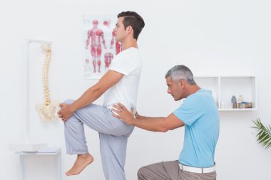 Doctor examining his patient back clipart