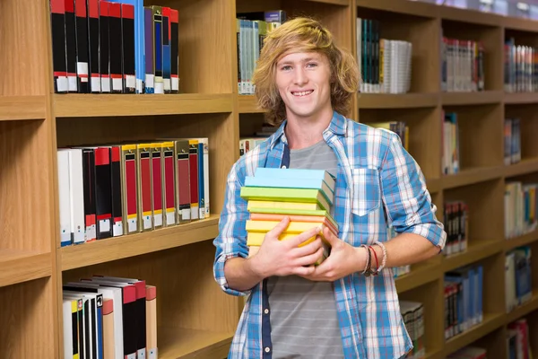 Φοιτητής χαμογελώντας σε κάμερα στη βιβλιοθήκη — Φωτογραφία Αρχείου