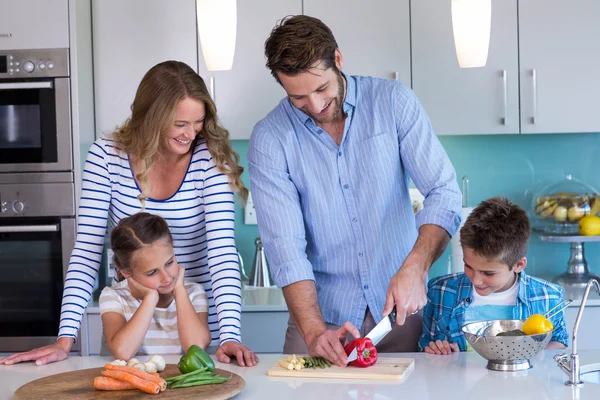 Família feliz preparando legumes juntos — Fotografia de Stock