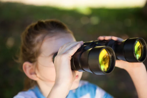 Söt liten flicka tittar genom kikare — Stockfoto