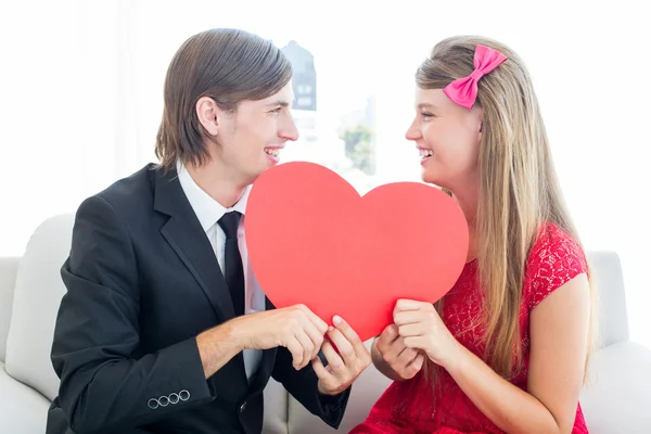 Geeky couple smiling and holding heart — Stock Photo, Image