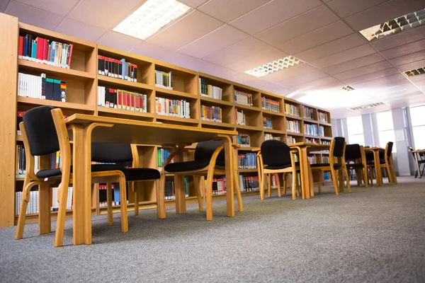 Volymer av böcker på bokhyllan i biblioteket — Stockfoto