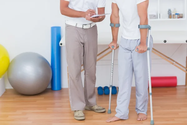 Doctor showing clipboard to patient — Stock Photo, Image