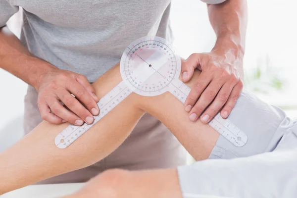 Doctor examining man leg — Stock Photo, Image