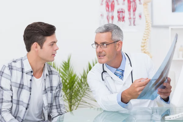 Doctor mostrando rayos X a su paciente — Foto de Stock