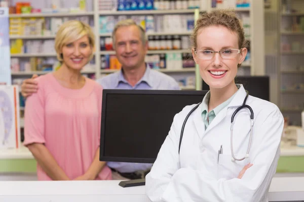 Farmacêutico e clientes sorrindo para a câmera — Fotografia de Stock