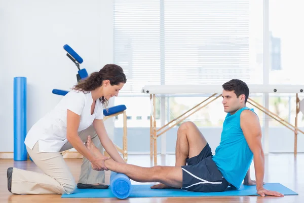 Trainer working with man on exercise mat — Stock Photo, Image
