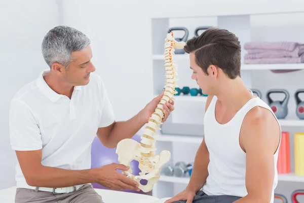 Doctor mostrando columna anatómica a su paciente — Foto de Stock