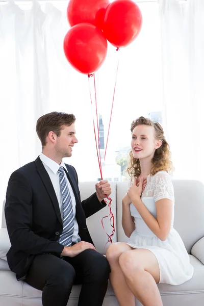 Businessman offering red balloons to his girlfriend — Stock Photo, Image