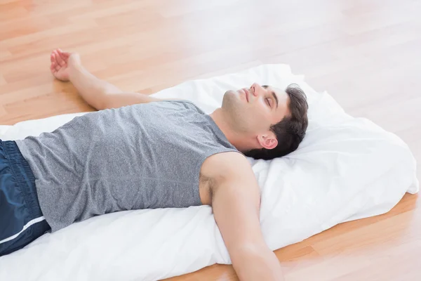 Hombre relajante en alfombra de ejercicio —  Fotos de Stock