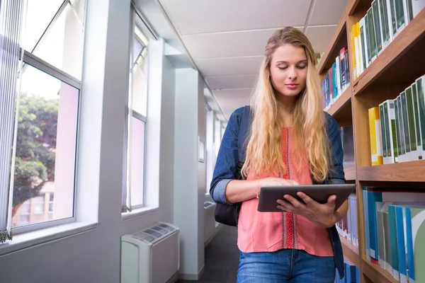 Estudante usando tablet na biblioteca — Fotografia de Stock