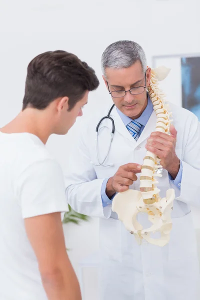 Doctor explaining anatomical spine to patient — Stock Photo, Image