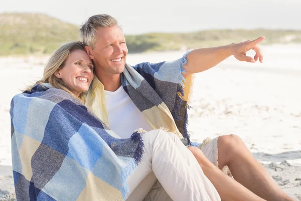 Happy couple wrapped up in blanket — Stock Photo, Image