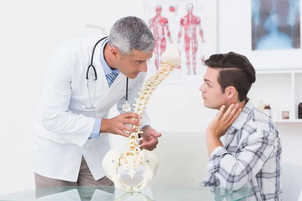 Doctor explaining anatomical spine to patient — Stock Photo, Image