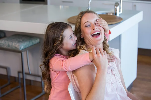 Happy little girl covering her mother eyes — Stock Photo, Image