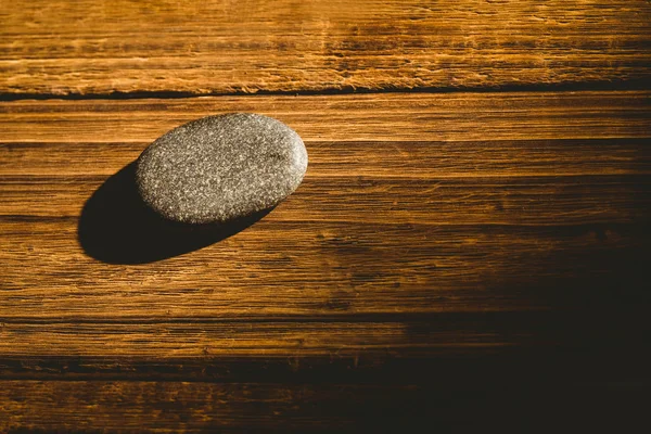 Sten på ett träbord — Stockfoto