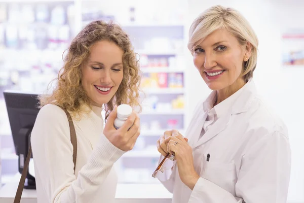 Farmacéutico sonriente y cliente discutiendo un producto —  Fotos de Stock