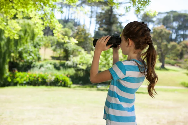 Roztomilá holčička při pohledu dalekohledem — Stock fotografie