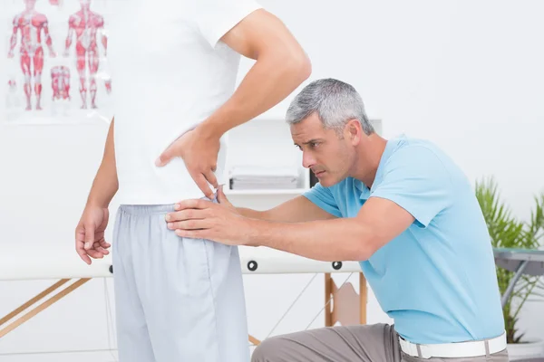 Doutor examinando seu paciente de volta — Fotografia de Stock