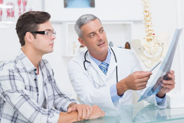 Arzt zeigt seinem Patienten Röntgenbilder — Stockfoto