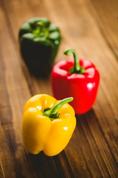 Tres pimientos en la tabla de cortar — Foto de Stock