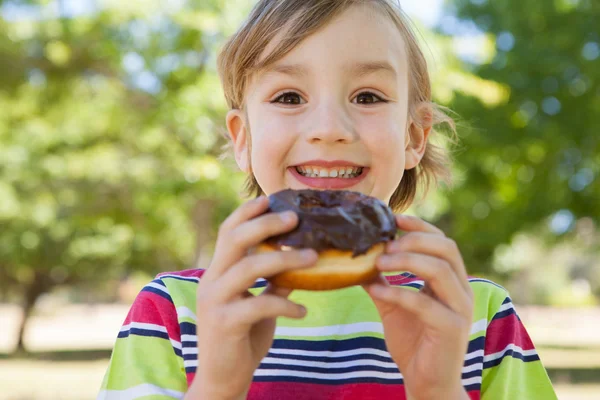 Menino comendo donut de chocolate — Fotografia de Stock