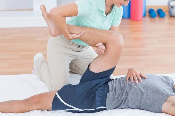 Man stretching with his trainer — Stock Photo, Image