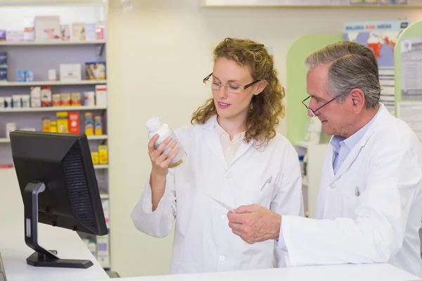 Team of pharmacists looking at medicine — Stock Photo, Image