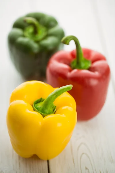 Tre paprika på skärbräda — Stockfoto