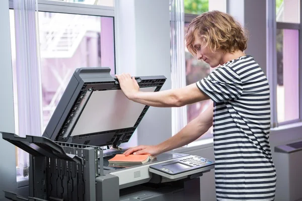 Student kopieerapparaat zijn boek in de bibliotheek — Stockfoto